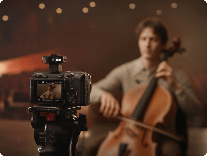 Pessoa tocando um violoncelo sendo grava por uma câmera profissional Sony com receptor do DJI MIC 3 conectado.